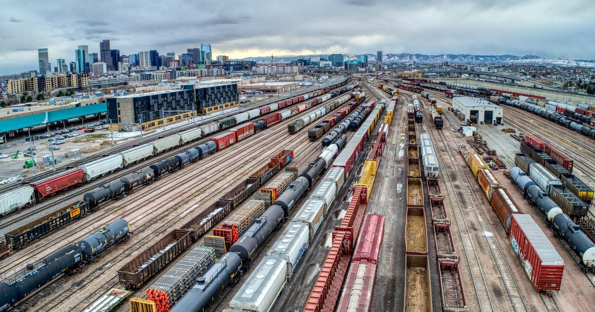 An aerial view of a railway marshalling yard, dozens of parallel tracks and ranked freight wagons stretching out of frame.