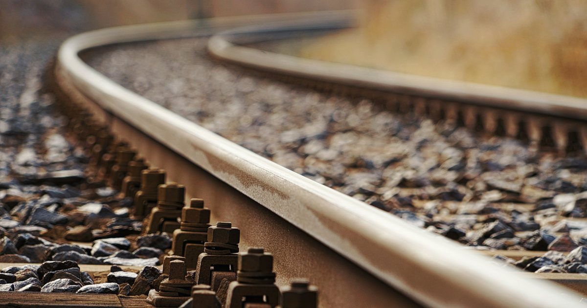 A railway switch on open track, the point blades set across so the rails divert onto a second line.